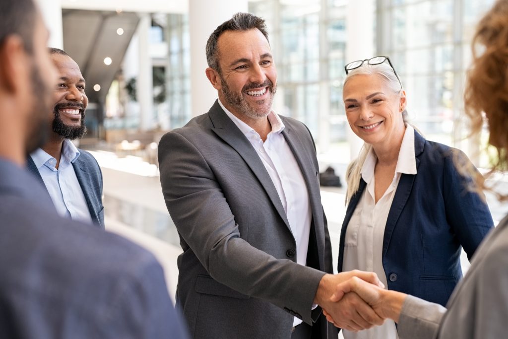 happy,mature,businessman,shaking,hands,with,businesswoman,in,modern,office.